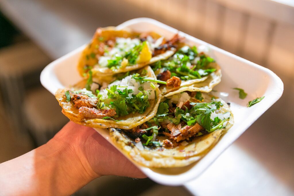 Al pastor tacos topped with pineapple, onion and cilantro