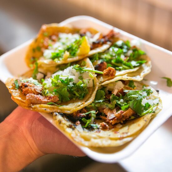 Al pastor tacos topped with pineapple, onion and cilantro