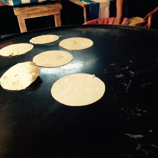 Corn tortillas cooking on a comal